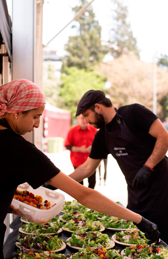 El equipo de Arrozadas del Empordà preparando una comida para un evento